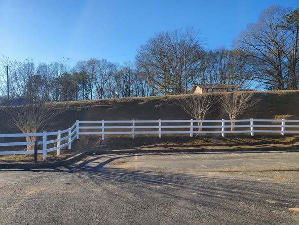 After: new 3 rail white vinyl fence along the entrance
