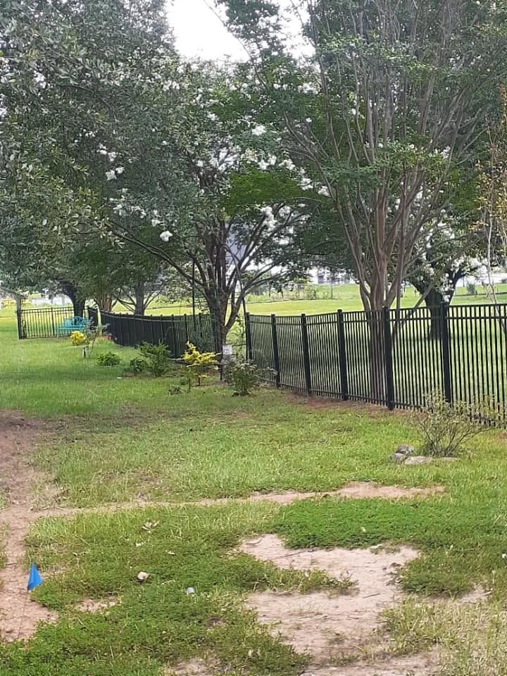 Black aluminum fence through a landscaped yard