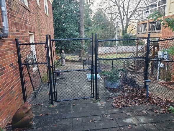 New 6 foot black chain link gates on a brick courtyard