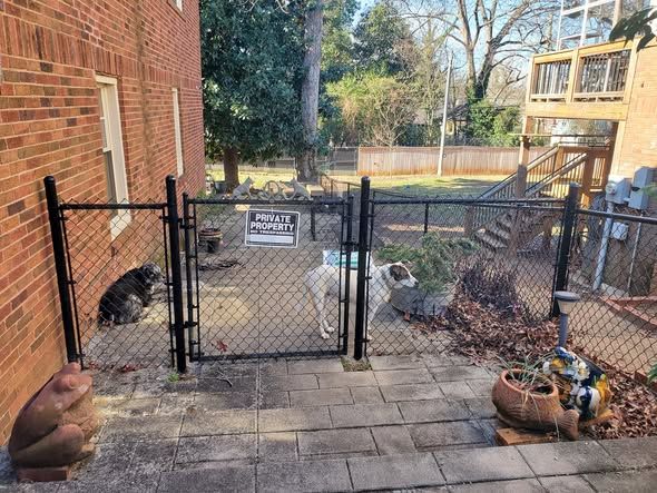 Black chain link extension securing a side courtyard