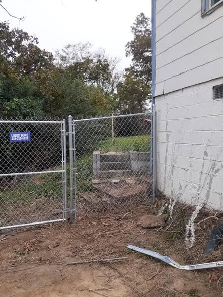 Chain link fence stepped along a hillside beside a house