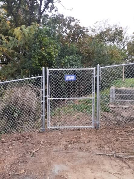 Galvanized chain link walk gate with Liberty Fence sign