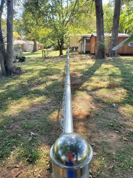Sight line down the top rail of a new galvanized chain link fence