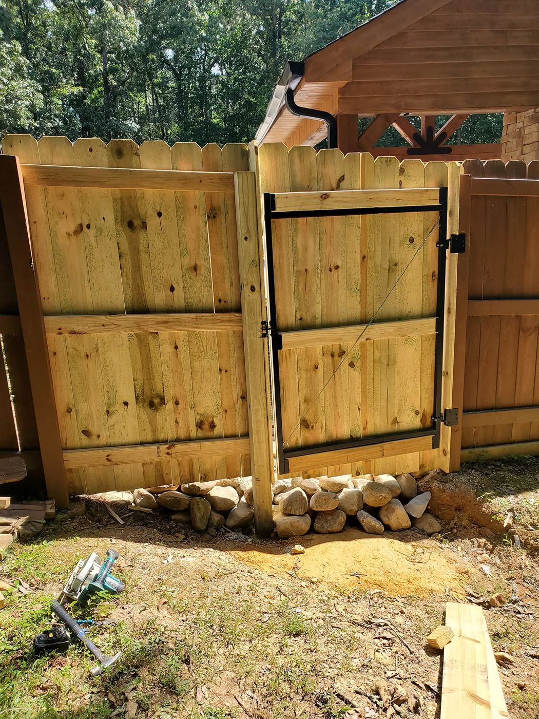 Wood privacy gate being hung on a steel frame