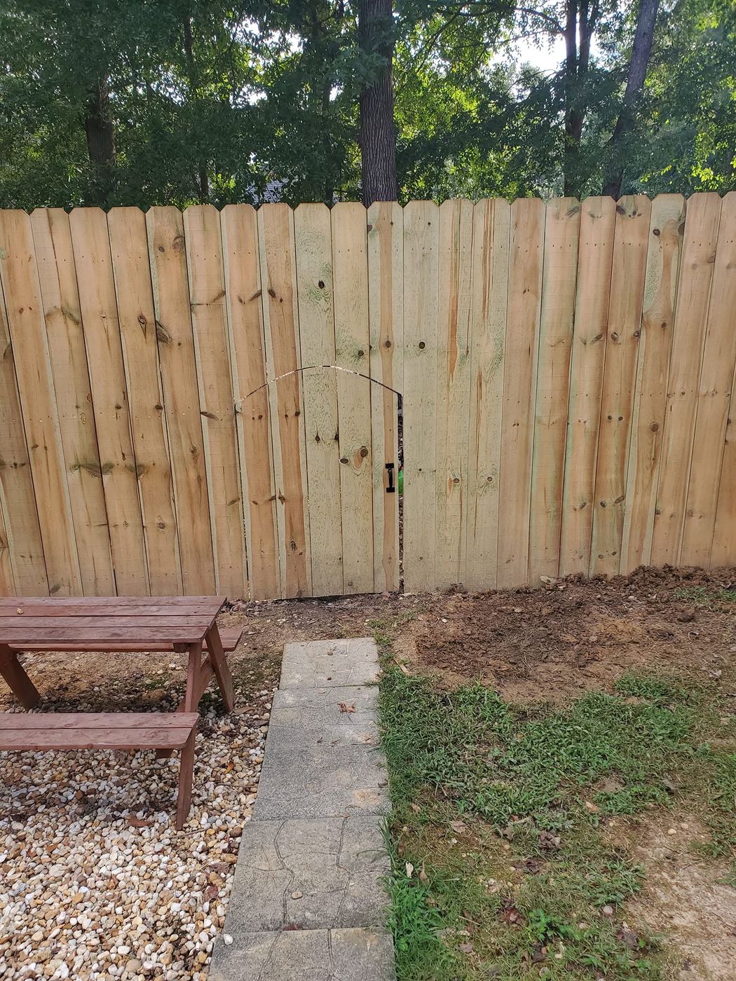 Wood privacy fence with arched walk gate cut into the line