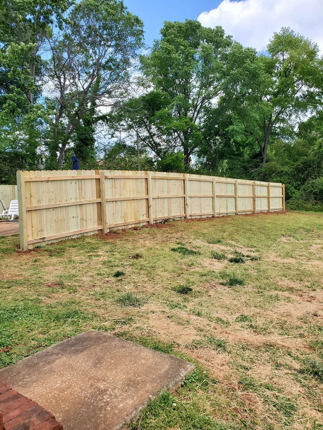 New wood privacy fence run enclosing a backyard