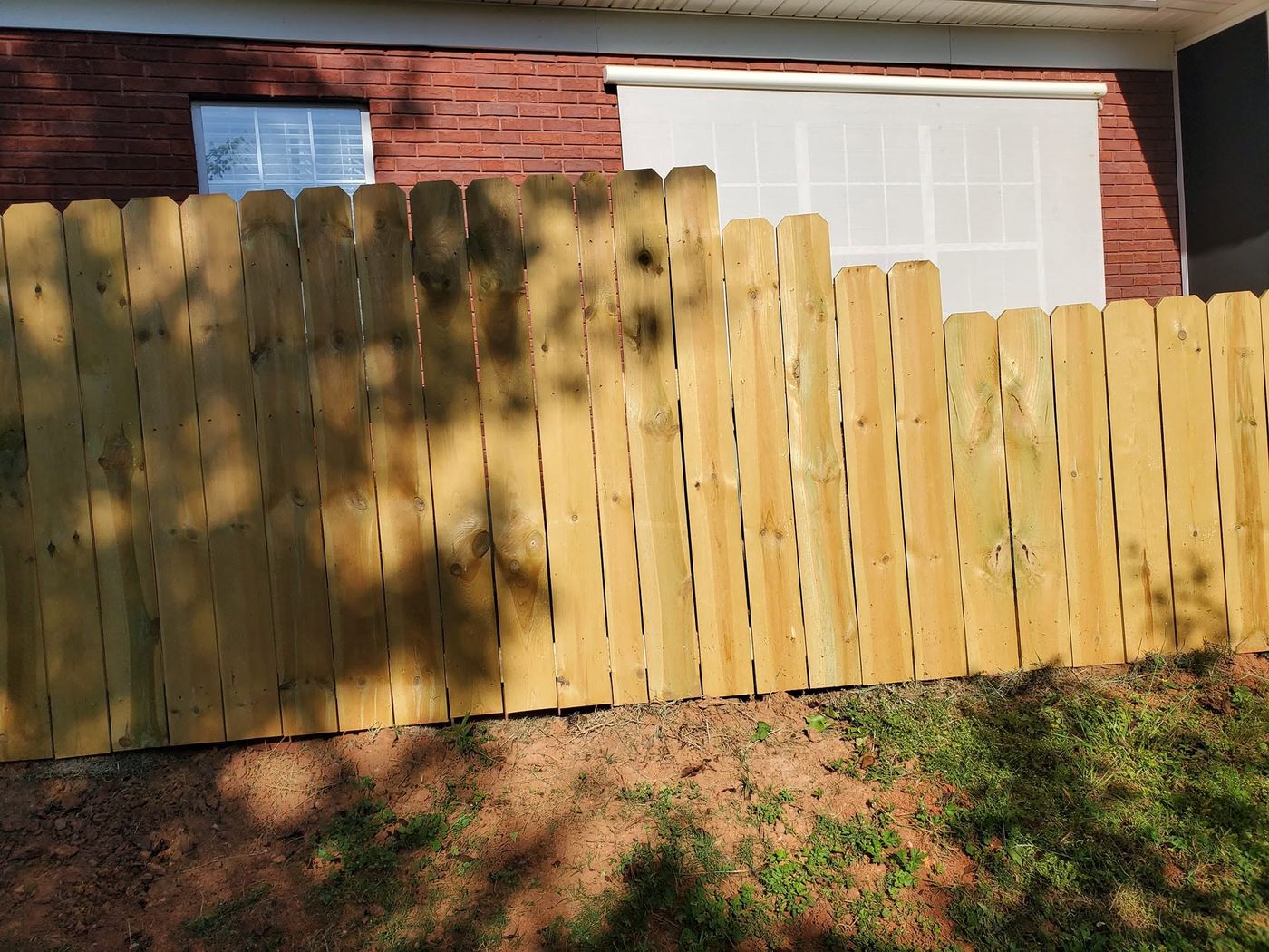 Dog ear wood privacy fence stepped along a grade